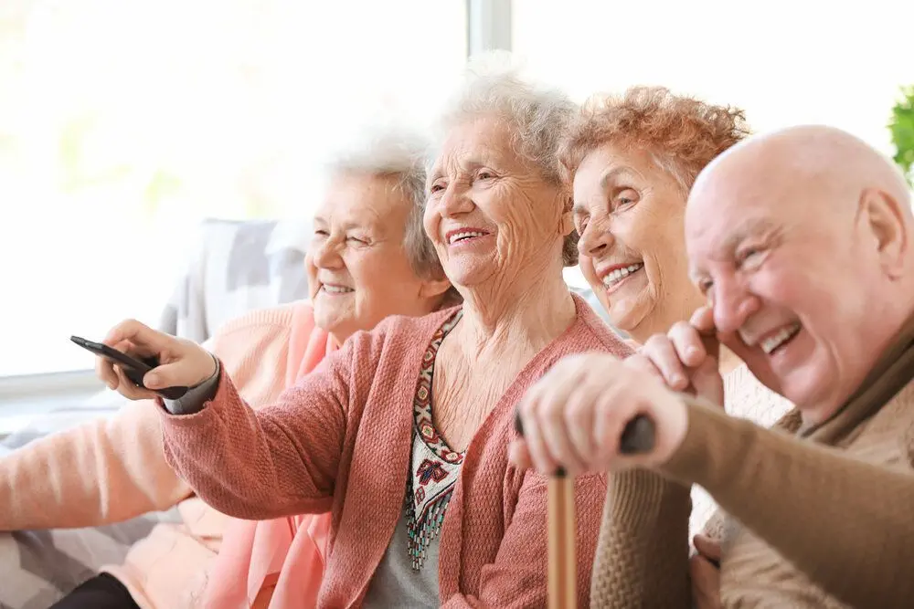 A group of elderly people watching TV
