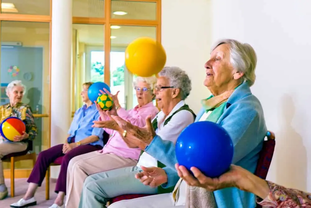 Care home residents playing ball games while sitting down