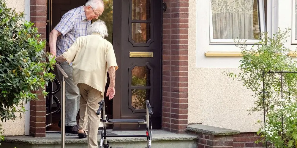 Elderly couple going into their house