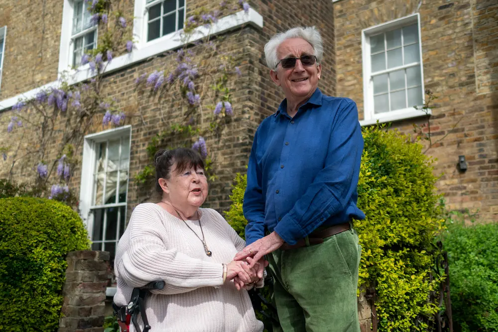 Elderly couple outside front garden