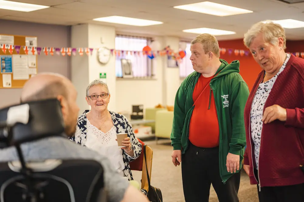 Group of older people chatting in a care home