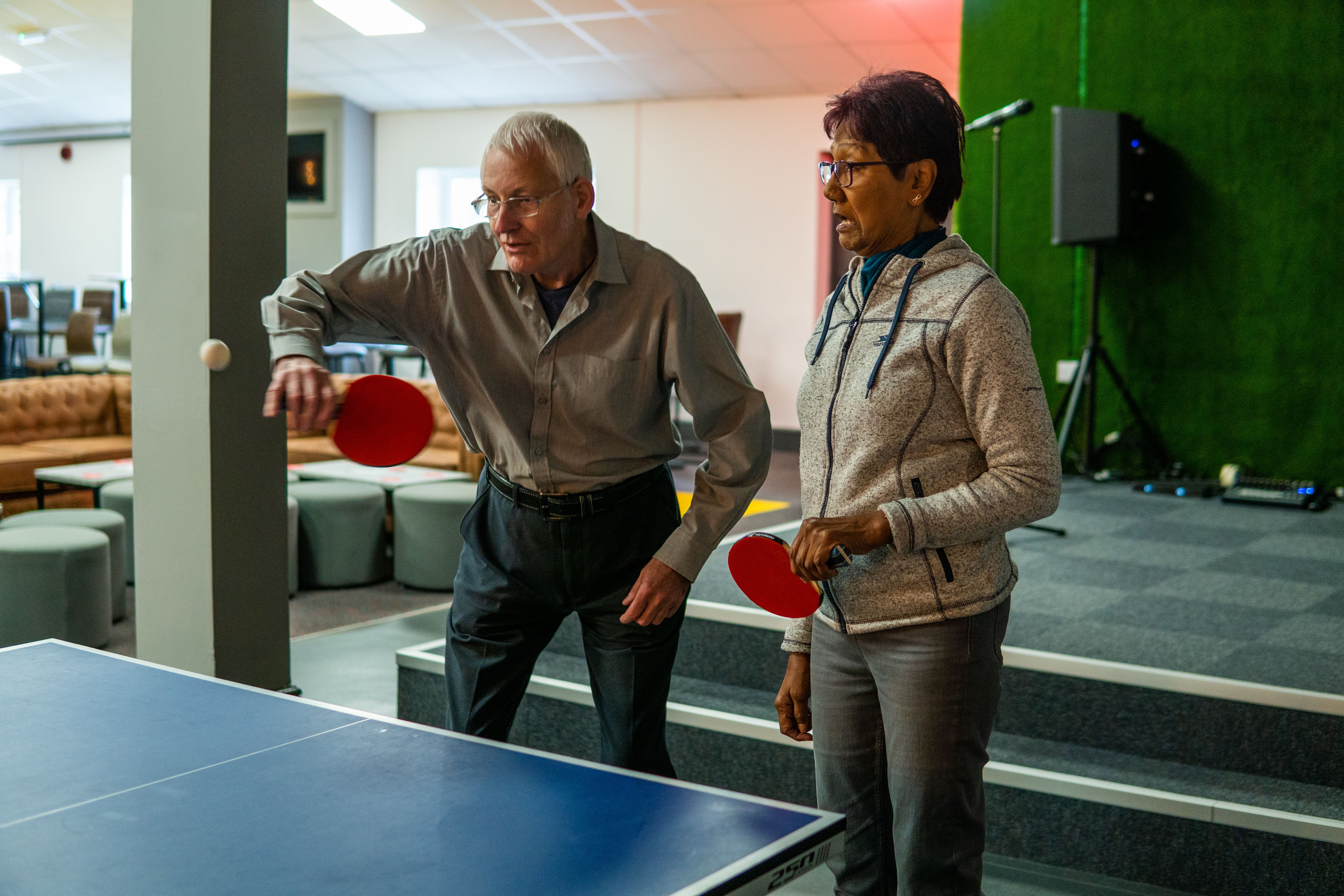 Man and woman playing table tennis together