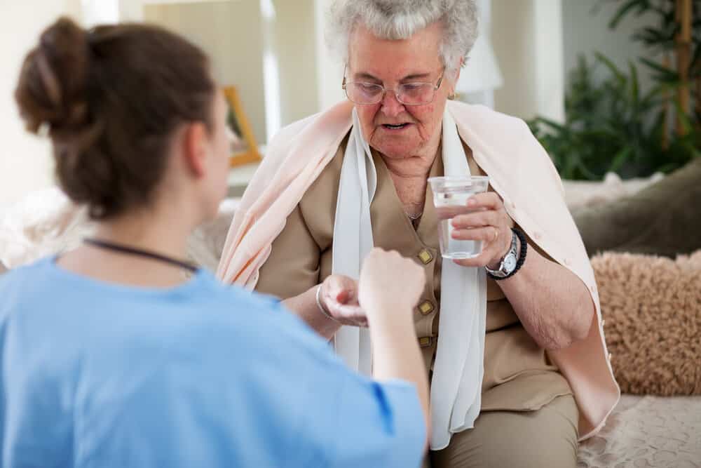 Nurse giving medicine to resident
