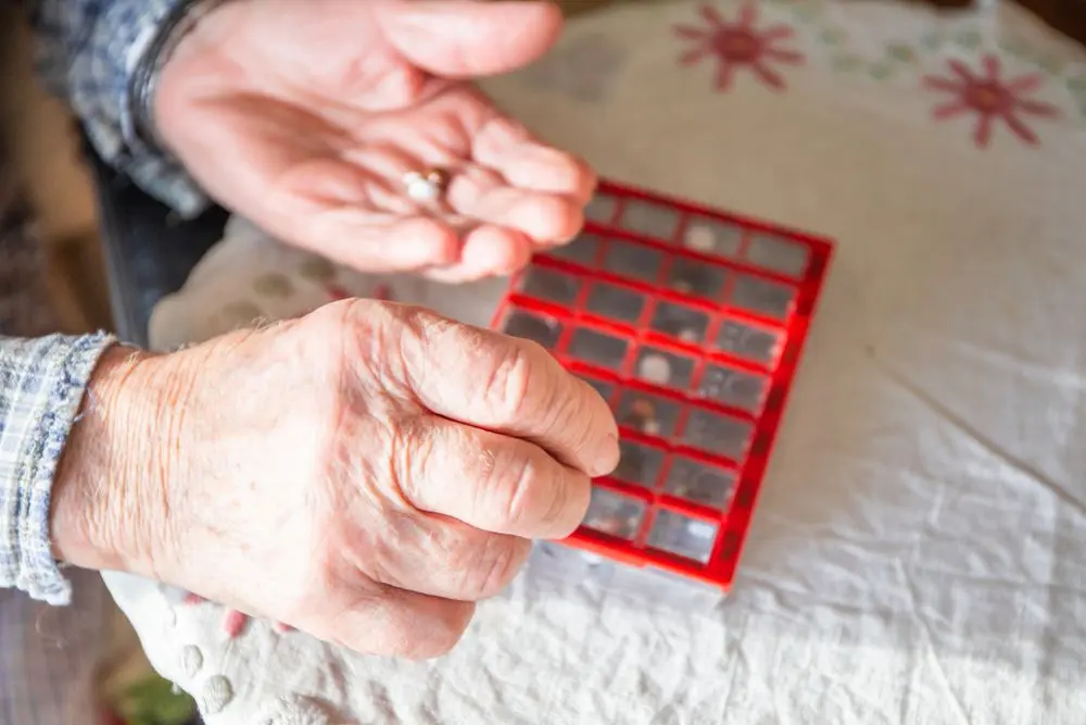 Older adult using a dosette box