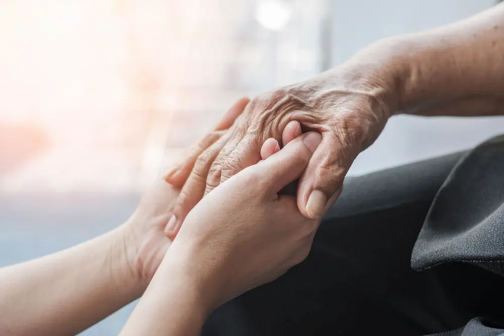 Older and younger hand holding