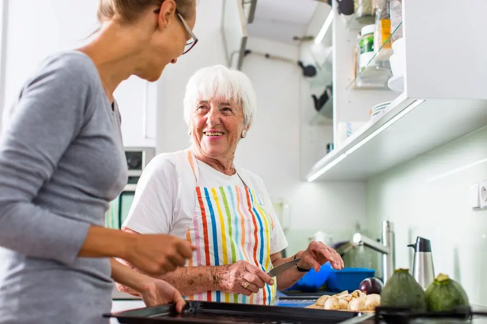 Older and younger woman cooking together