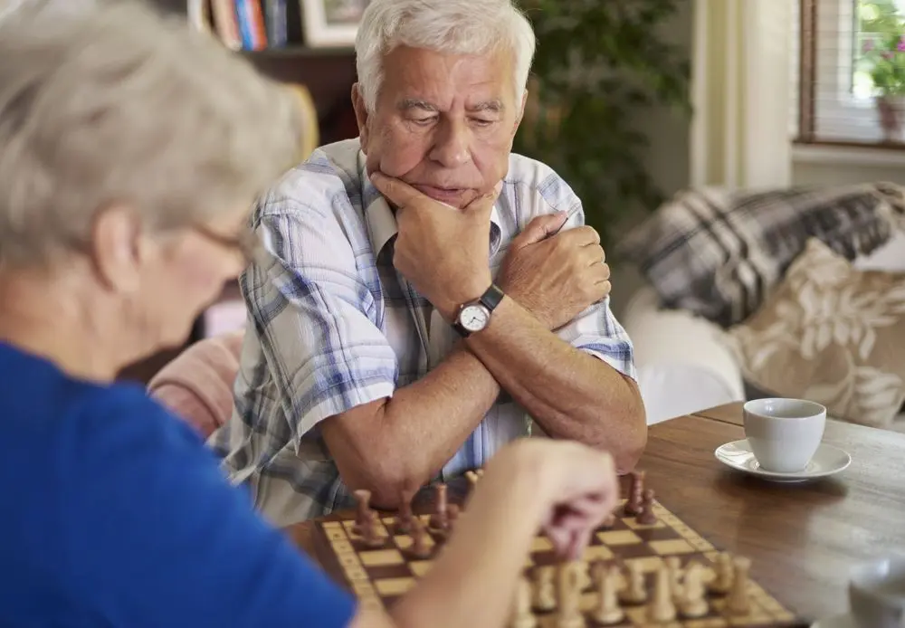 Older man and woman playing chess