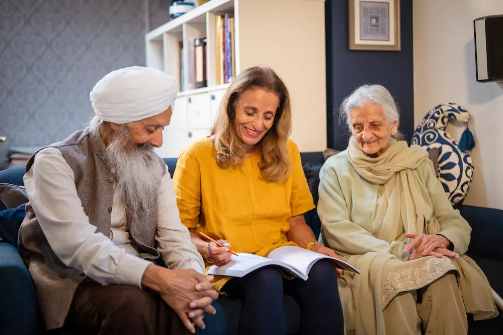 Younger woman and elderly couple reading a book