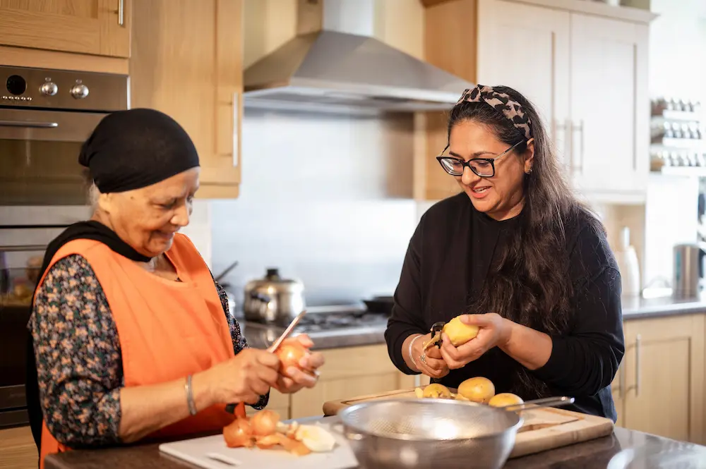 Younger woman and older woman preparing food together